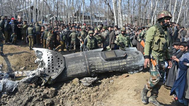 Indische Soldaten und Anwohner stehen in Kaschmir um die Reste eines abgestürzten Militärhubschraubers