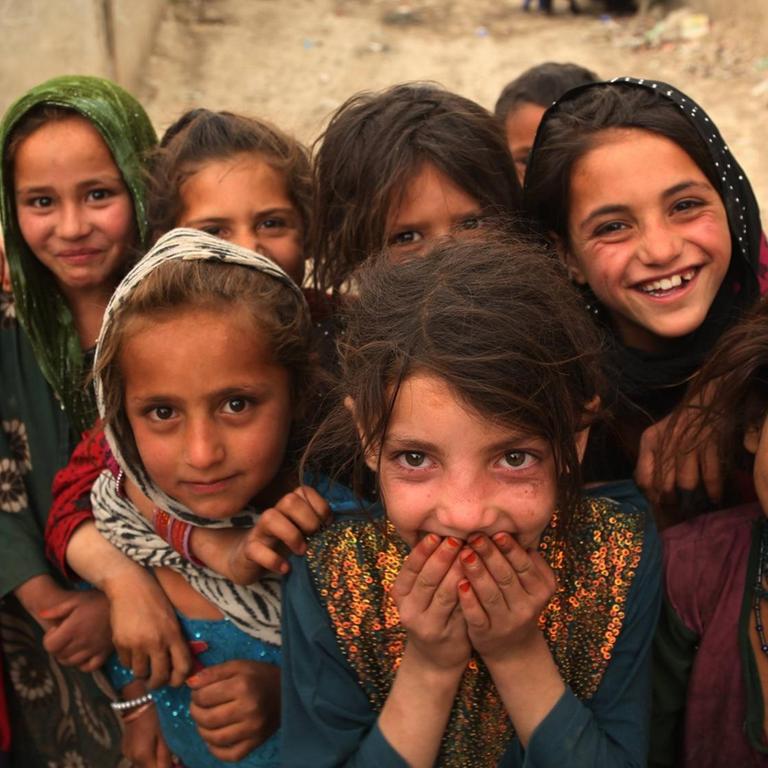 Eine Gruppe junger Mädchen steht in einer schmalen Gasse. Die Kinder blicken in die Kamera.