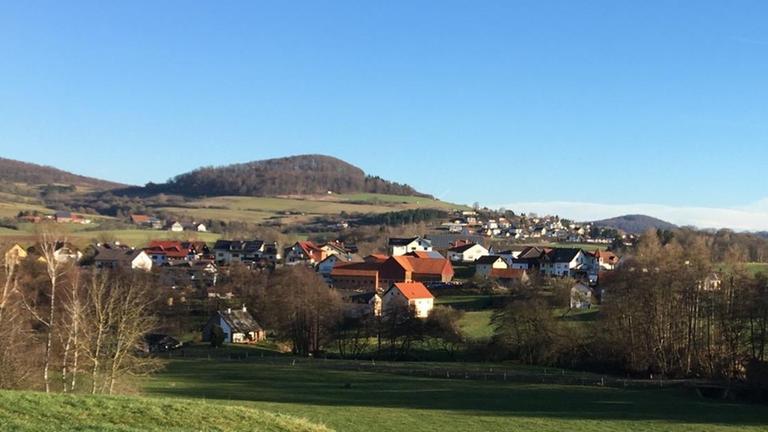 Zwischen sanften Hügeln und in Mitten grüner Wiesen liegt der Ort Nüsttal in Hessen.