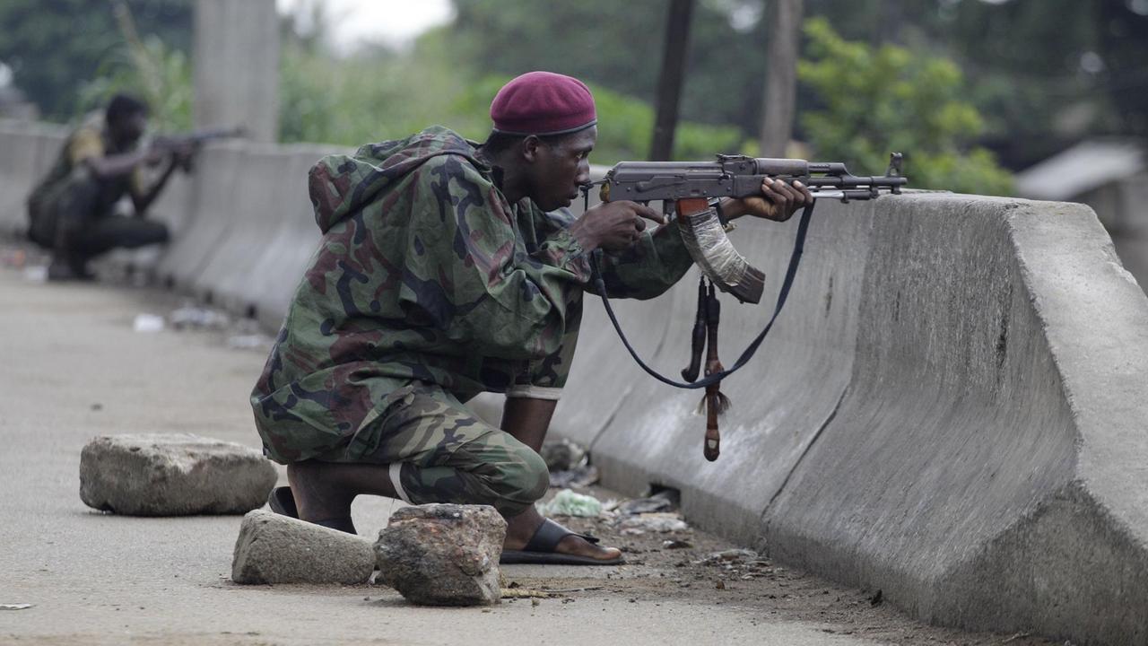 Während der Unruhen in der Elfenbeinküste 2011: Soldaten, die den Politiker Alassane Ouattara unterstützen, an einem Checkpoint in Abidjan. Während der Unruhen in der Elfenbeinküste 2011: Soldaten, die den Politiker Alassane Ouattara unterstützen, an einem Checkpoint in Abidjan.