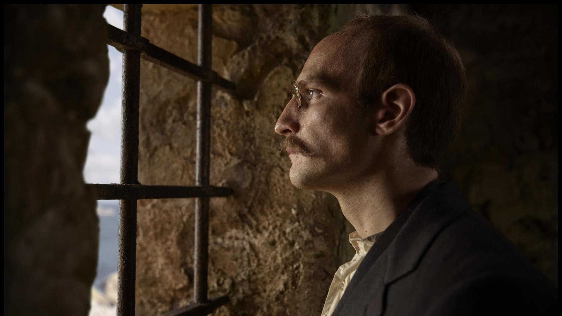 Eine Filmszene aus Polanskis Film Intrige zeigt den vermeintlichen Verräter Alfred Dreyfus (Louis Garrel) hinter Gittern.