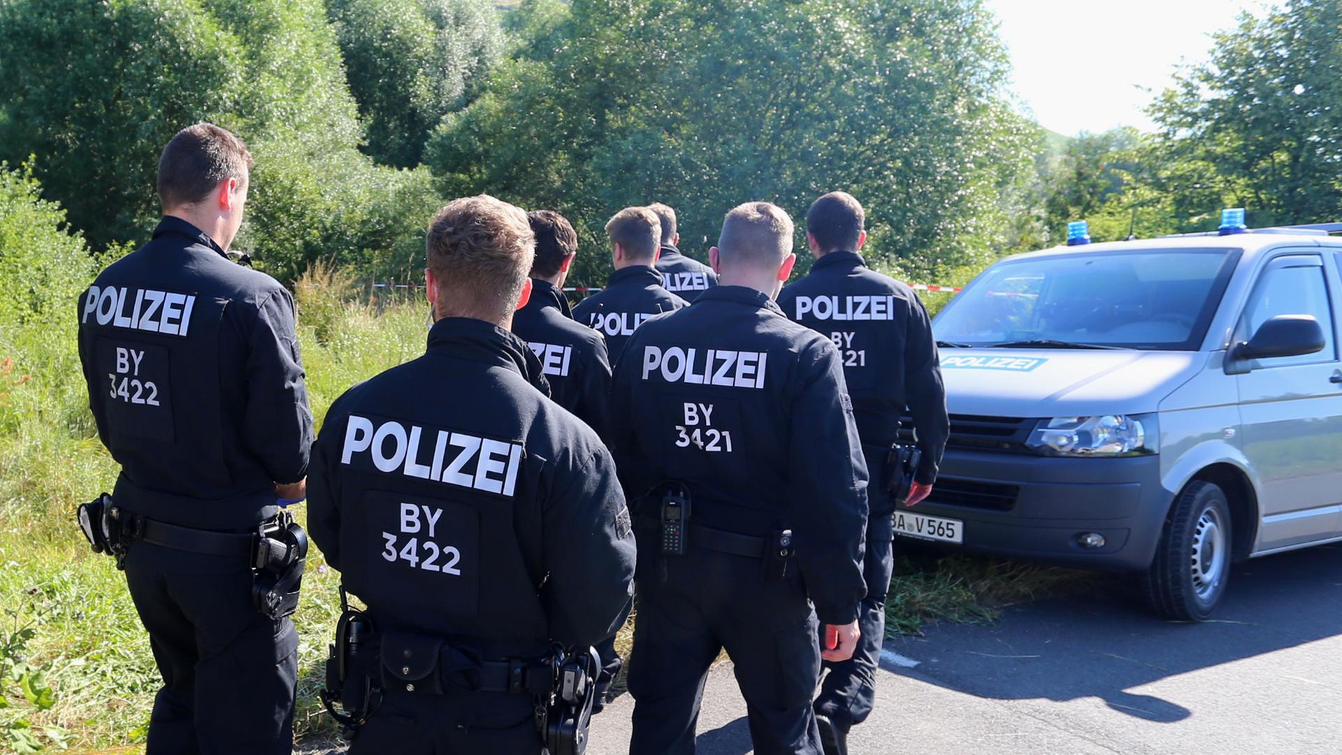 Polizisten durchsuchen am 19.07.2016 neben einem Weg bei Würzburg (Bayern) das Gelände nach Spuren. Am Montagabend war ein 17 Jahre alter Afghane mit einer Axt und einem Messer auf Fahrgäste in einem Regionalzug bei Würzburg-Heidingsfeld losgegangen. Polizisten durchsuchen am 19.07.2016 neben einem Weg bei Würzburg (Bayern) das Gelände nach Spuren. Am Montagabend war ein 17 Jahre alter Afghane mit einer Axt und einem Messer auf Fahrgäste in einem Regionalzug bei Würzburg-Heidingsfeld losgegangen.