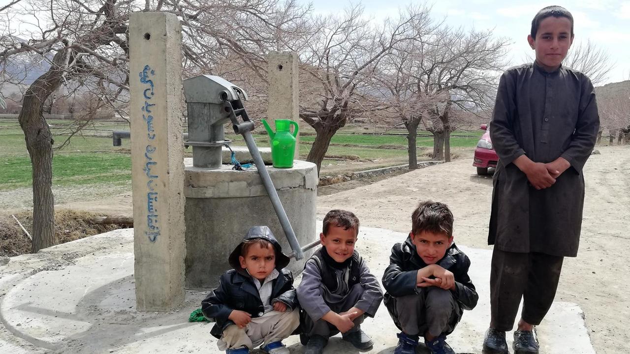 Vier Kinder im afghanischen Dorf Mussahi. Im Hintergrund ist ein Brunnen zu sehen. Vier Kinder im afghanischen Dorf Mussahi. Im Hintergrund ist ein Brunnen zu sehen.