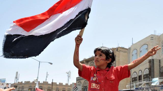 Ein Kind hält im Jemen die Flagge des Landes