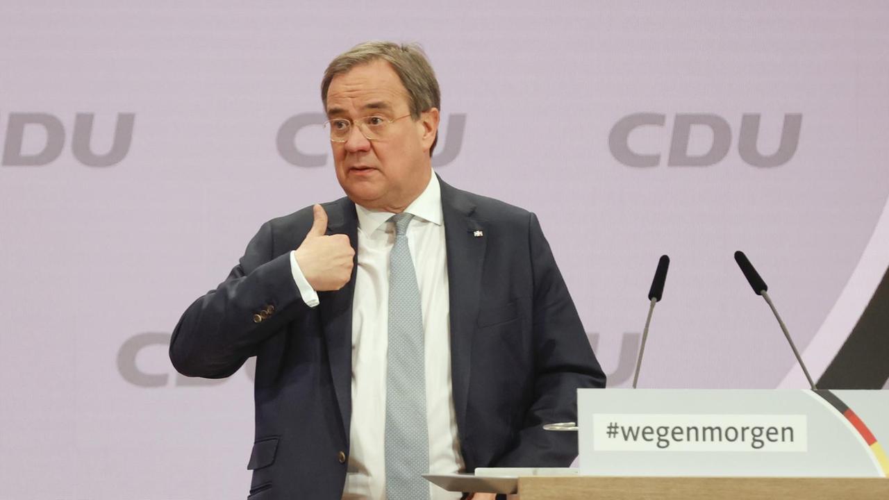 Armin Laschet steht vor dem Rednerpult beim CDU-Parteitag und hebt den Daumen seiner rechten Hand. Armin Laschet steht vor dem Rednerpult beim CDU-Parteitag und hebt den Daumen seiner rechten Hand.