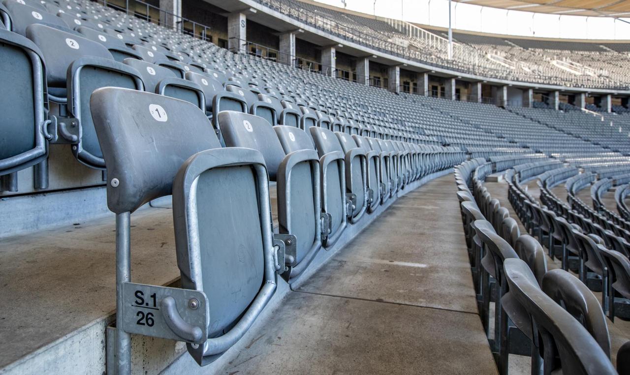 Die Sitze in den Reihen des menschenleeren Olympiastadions sind hochgeklappt. Die Sitze in den Reihen des menschenleeren Olympiastadions sind hochgeklappt.