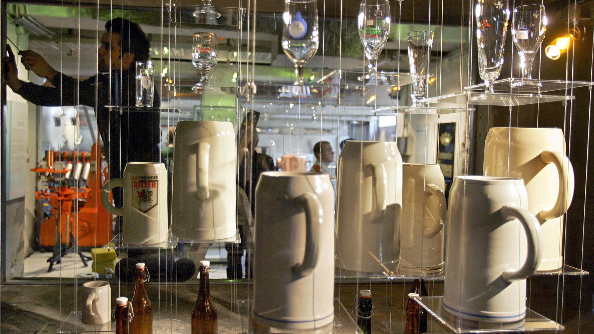 Bierkrüge, Flaschen und Gläser werden im Brauerei-Museum in Dortmund in einer Vitrine präsentiert. Bierkrüge, Flaschen und Gläser werden im Brauerei-Museum in Dortmund in einer Vitrine präsentiert.