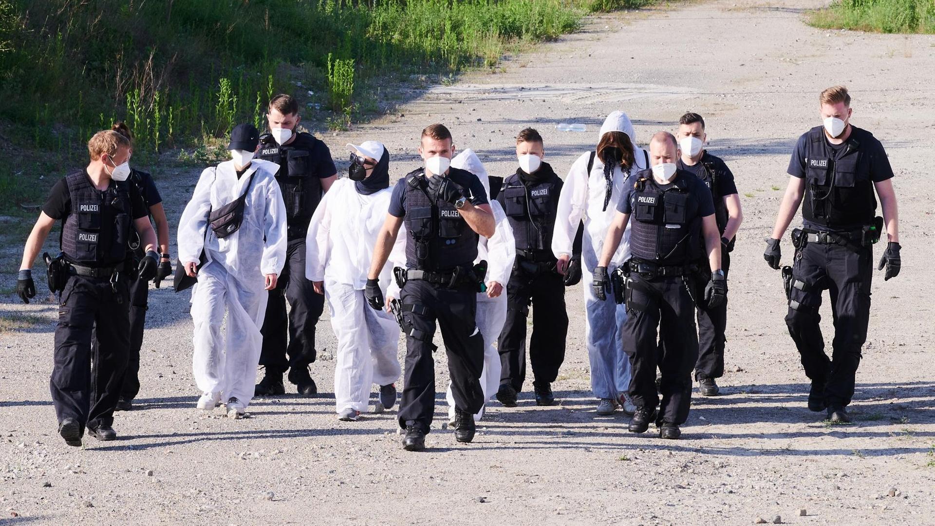 Polizisten und Umweltaktivisten der Initiative „Robin Wood“ verlassen das abgesperrte Gelände an der Baustelle der Autobahn A100 an der Sonnenallee. Polizisten und Umweltaktivisten der Initiative „Robin Wood“ verlassen das abgesperrte Gelände an der Baustelle der Autobahn A100 an der Sonnenallee.
