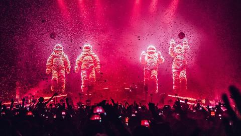 Die Chemical Brothers in Anzügen bei einem Live-Konzert.