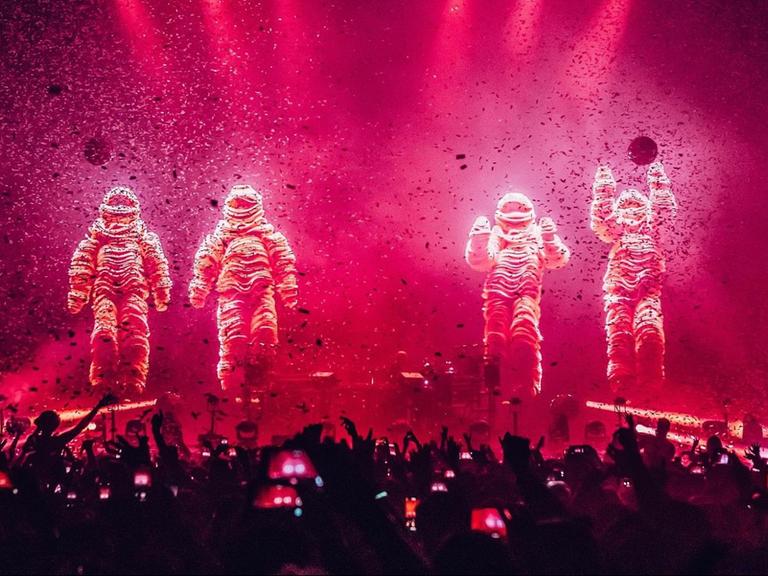 Die Chemical Brothers in Anzügen bei einem Live-Konzert.