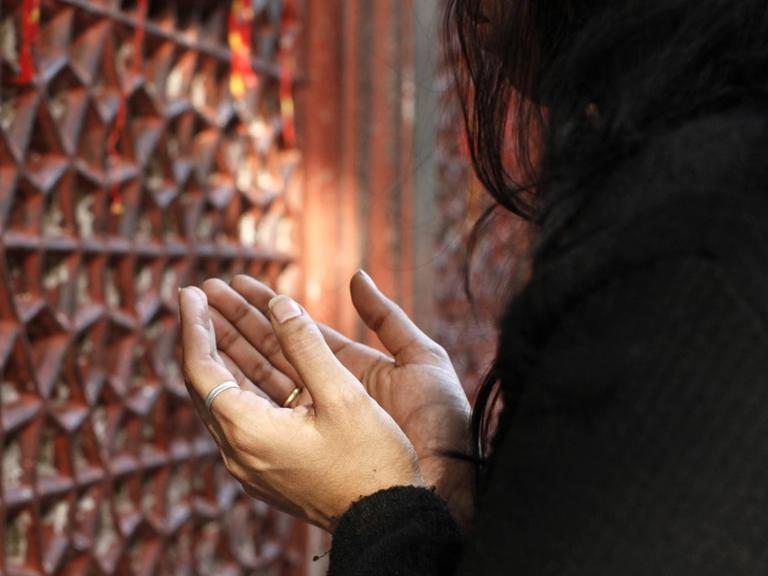 Eine betende Frau in Nizzamuddin Dargah