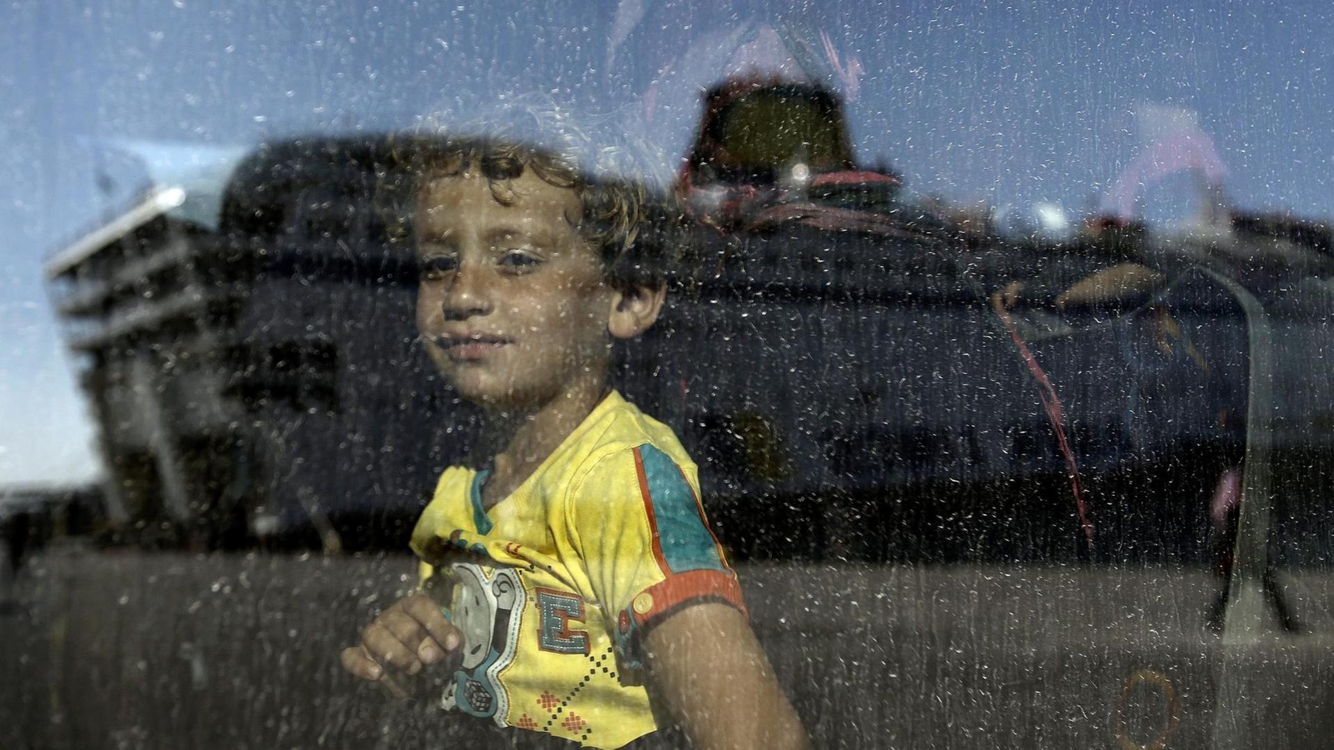 Ein syrisches Kind schaut durch die Scheibe in einem Bus Ein syrisches Kind schaut durch die Scheibe in einem Bus