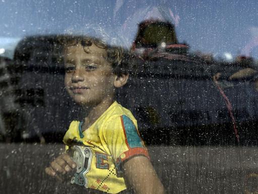 Ein syrisches Kind schaut durch die Scheibe in einem Bus