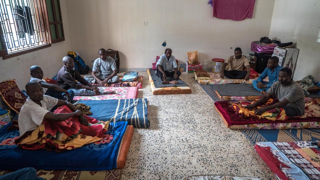 Das Bild zeigt Migranten aus der Elfenbeinküste, die im libyschen Misrata als Illegale in ein Internierungslager gebracht wurden. Sie setzen auf Matrazen auf dem Boden. Das Gebäude war früher eine Schule. 