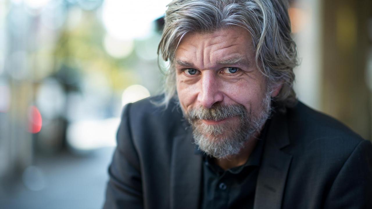 Der norwegische Schriftsteller Karl Ove Knausgard sitzt vor einem Hotel in Berlin. Der norwegische Schriftsteller Karl Ove Knausgard sitzt vor einem Hotel in Berlin.