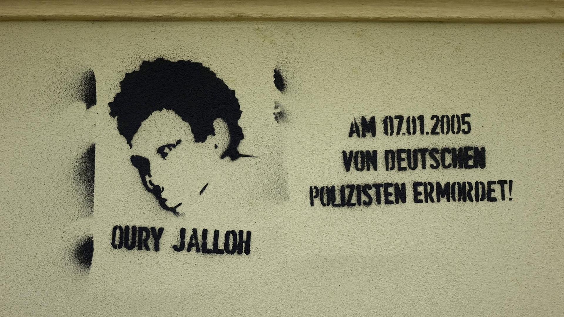 Ein Graffiti wurde an eine Hauswand gesprüht. Da steht:Oury Jalloh, von deutschen Polizisten ermordet. Ein Graffiti wurde an eine Hauswand gesprüht. Da steht:Oury Jalloh, von deutschen Polizisten ermordet.