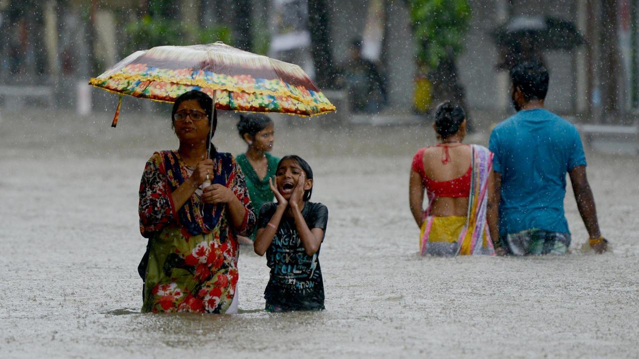 In Mumbai waten Menschen am 29. August 2017 über eine überflutete Straße. In Mumbai waten Menschen am 29. August 2017 über eine überflutete Straße.