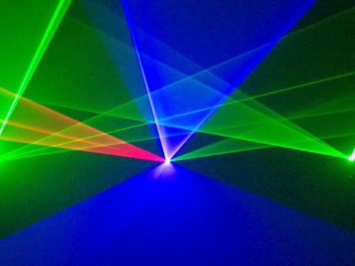 Lasershow, konzipiert von Michael Ramjoué: grüne, blaue und rote Lichtkegel vor schwarzem Hintergrund überschneiden sich