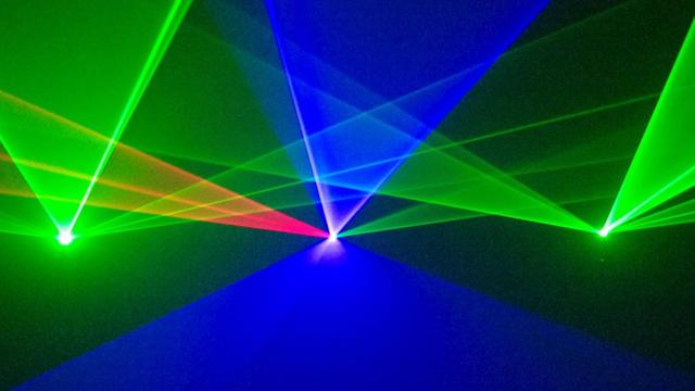 Lasershow, konzipiert von Michael Ramjoué: grüne, blaue und rote Lichtkegel vor schwarzem Hintergrund überschneiden sich