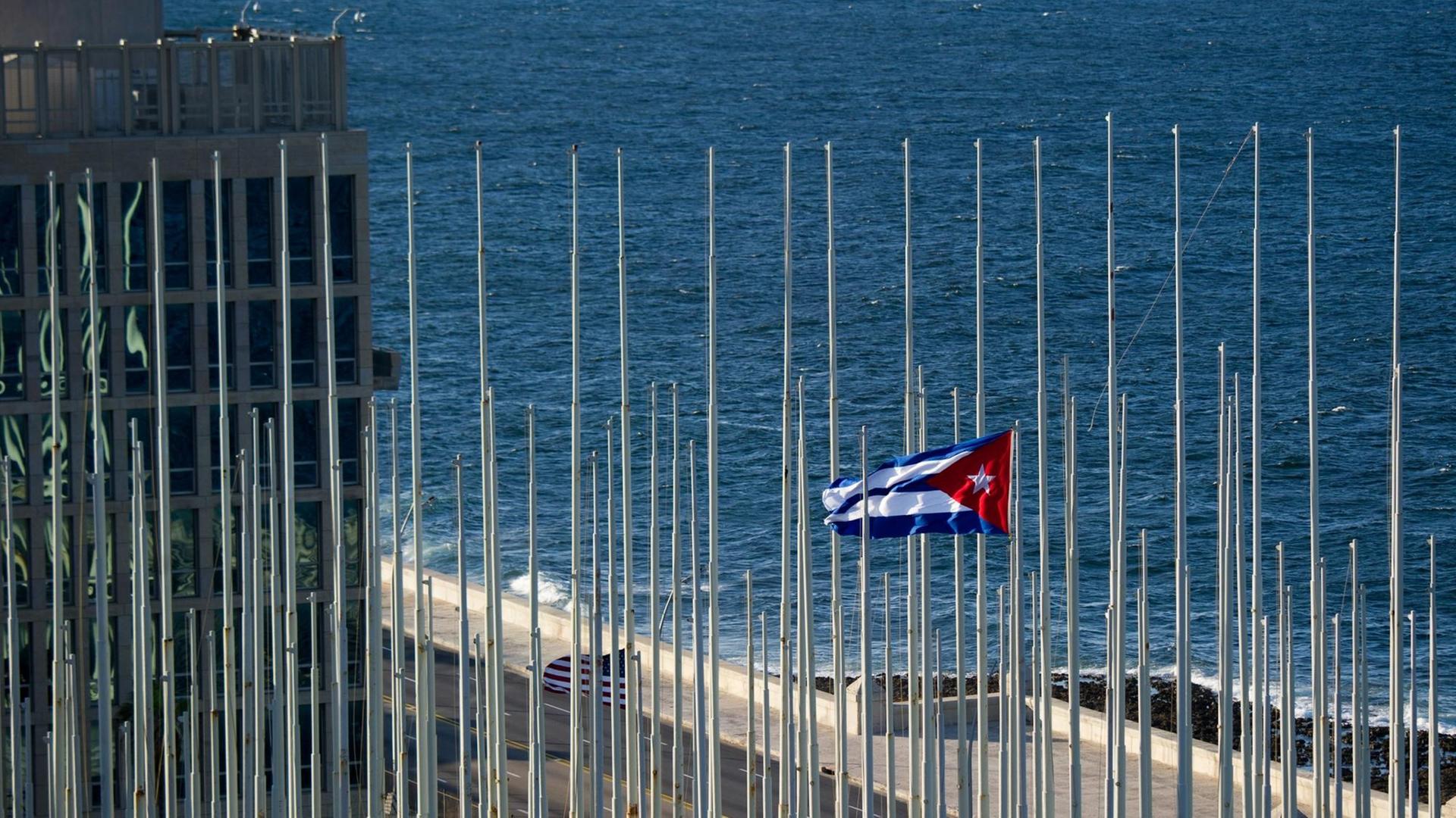 Eine kubanische Fahne weht vor der US-Botschaft in Havanna, Kuba. Im Hintergrund ist das Meer zu sehen. Eine kubanische Fahne weht vor der US-Botschaft in Havanna, Kuba. Im Hintergrund ist das Meer zu sehen.