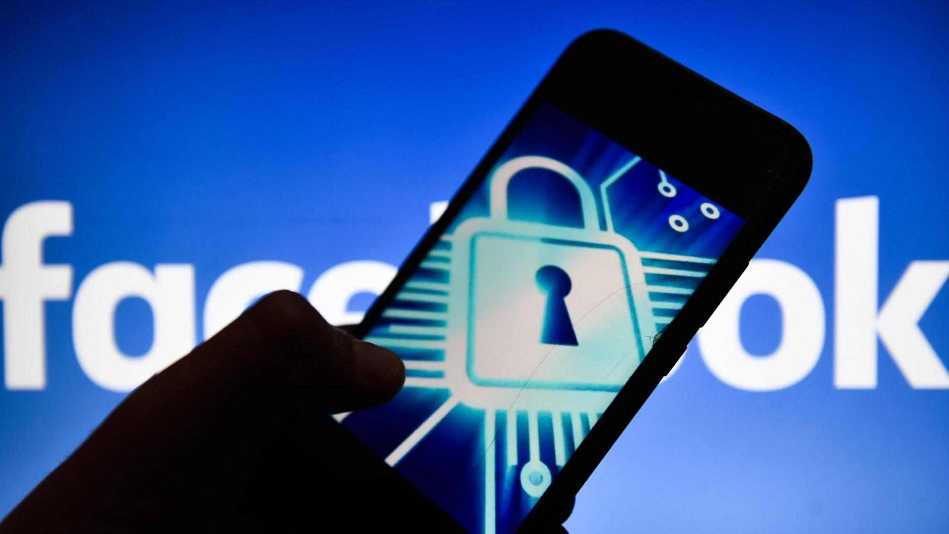 Cyber Schloss Symbol auf einem Android Smartphone, im Hintergrund das Facebook Logo Cyber Schloss Symbol auf einem Android Smartphone, im Hintergrund das Facebook Logo