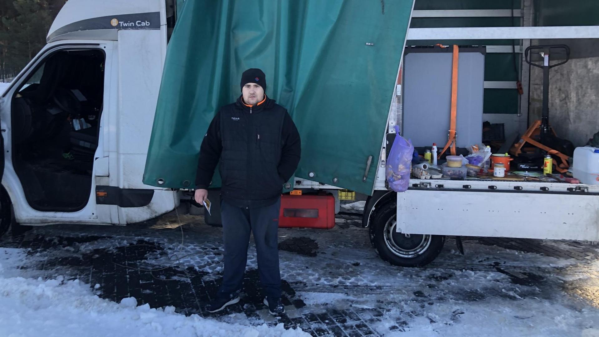 Oleg, ein Fahrer aus der Ukraine, kocht auf der Ladefläche seines LkW sein Mittagessen auf der Raststätte Michendorf