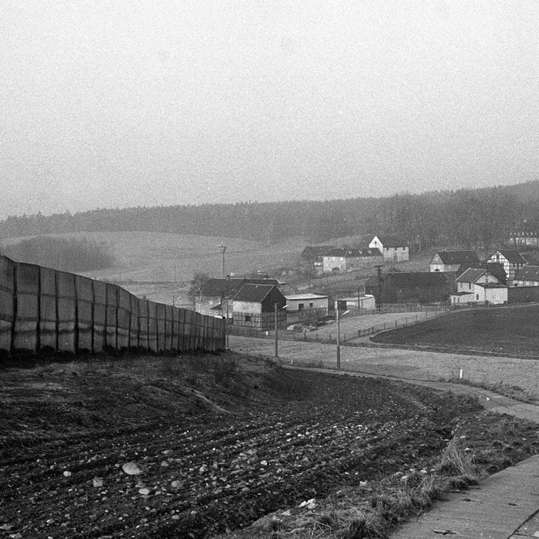 Schwarzaufnahme eines bayerischen Dorfes mit wenigen Häusern, unweit einer innerdeutschen Grenzanlage.