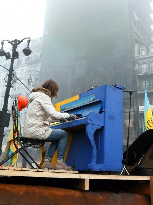 Eine Frau spielt Klavier bei den Protesten auf dem Majdan in Kiew am 10. Februar 2014.