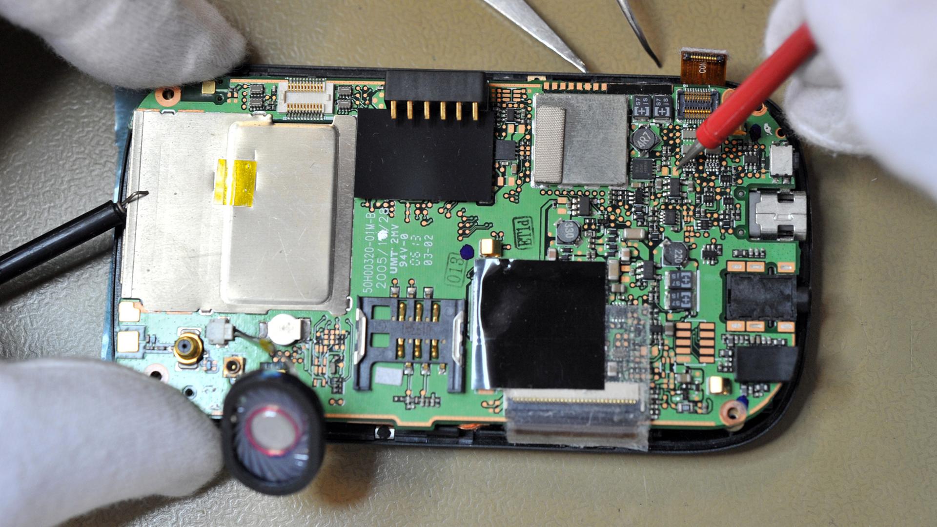 ComBase-Mitarbeiter repariert am Montag in der Handy-Reparaturwerkstatt in Bocholt ein Mobiltelefon. ComBase-Mitarbeiter repariert am Montag in der Handy-Reparaturwerkstatt in Bocholt ein Mobiltelefon.
