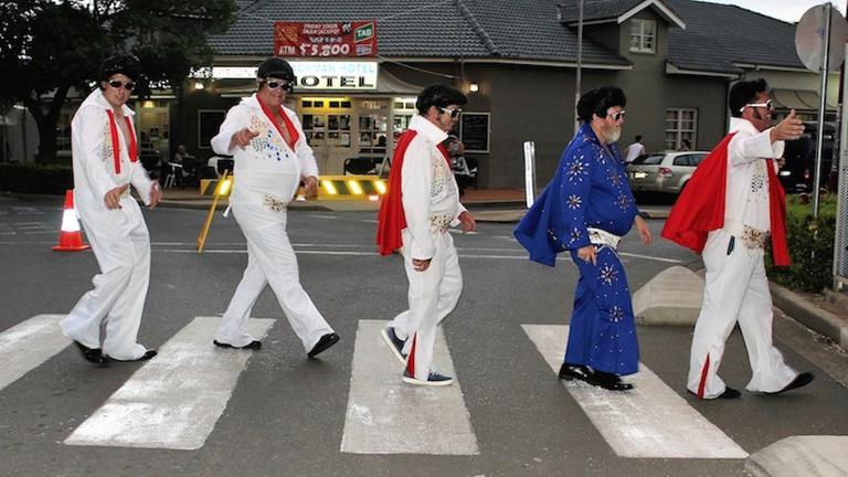 Elvis-Darsteller überqueren einen Zebrastreifen. Elvis-Darsteller überqueren einen Zebrastreifen.