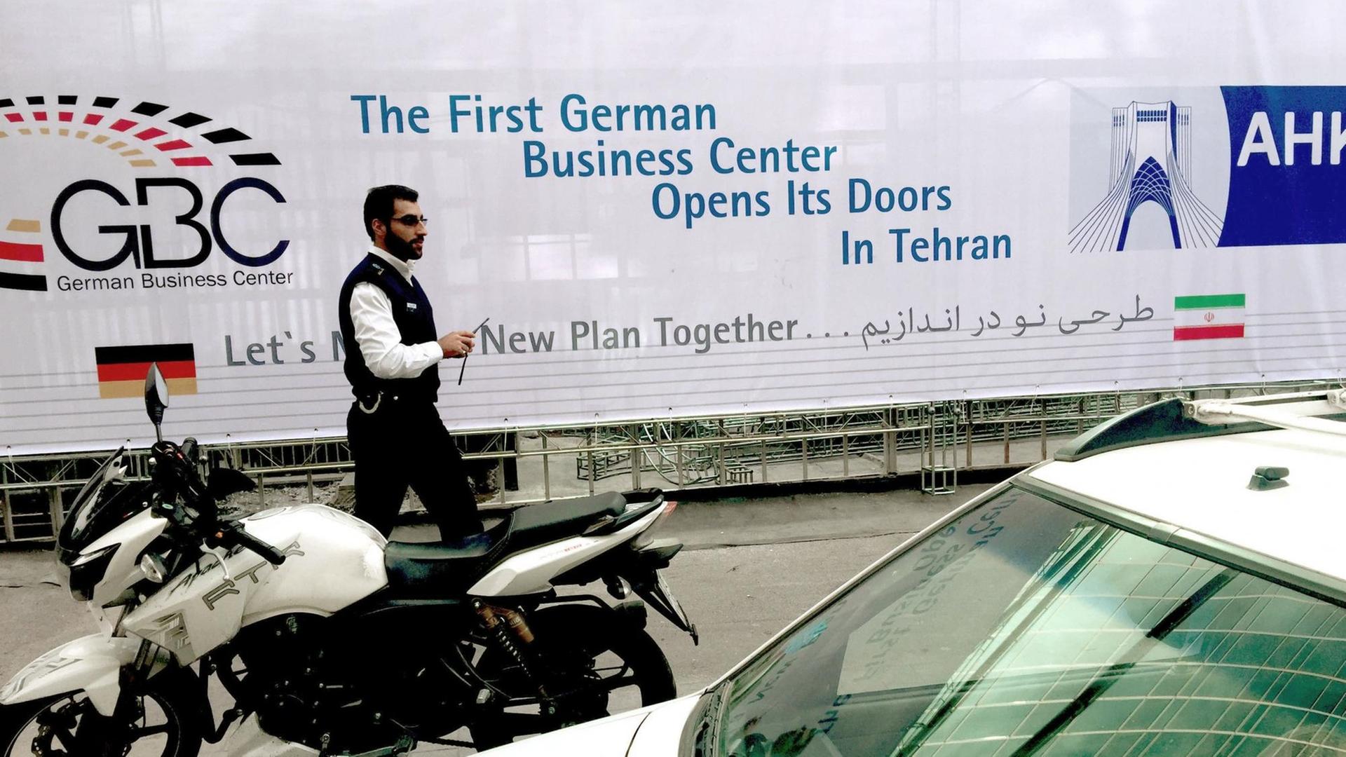 Ein Mann geht am 02.11.2017 in Teheran im Iran an einem Banner mit der Aufschrift "First German Business Center Opens its Doors in Tehran" vorbei. Ein Mann geht am 02.11.2017 in Teheran im Iran an einem Banner mit der Aufschrift "First German Business Center Opens its Doors in Tehran" vorbei.