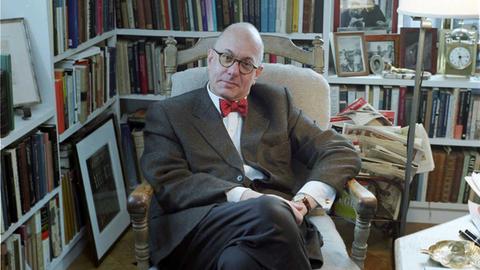 Leon Botstein in einem Lehnsessel, umgeben von Regalen mit Büchern und Fotos