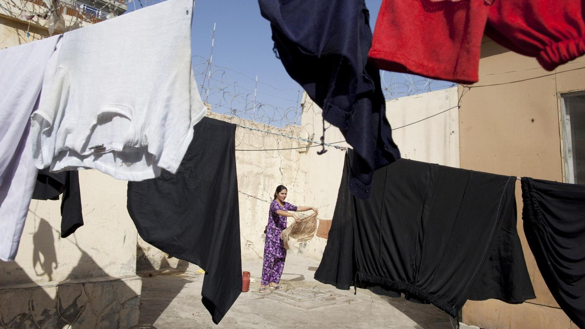 Blick in den Innenhof der Haftanstalt für Frauen in Mazar-E-Sharif in Afghanistan, in dem eine Wäscheleine hängt, im Hintergrund ist eine Frau zu sehen, aufgenommen im Oktober 2010
