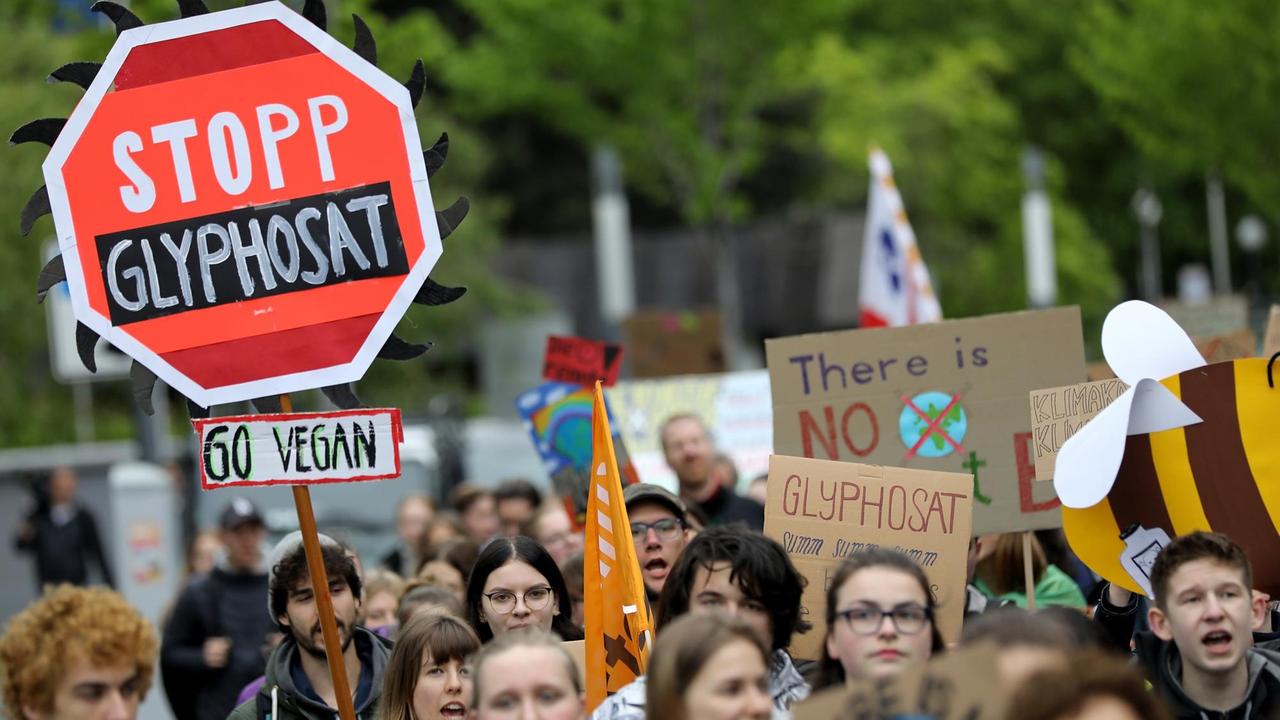 Klima-Aktivisten der "Fridays for Future"-Bewegung gehen zur Hauptversammlung von Bayer mit einem Schild "Stopp Glyphosat". 