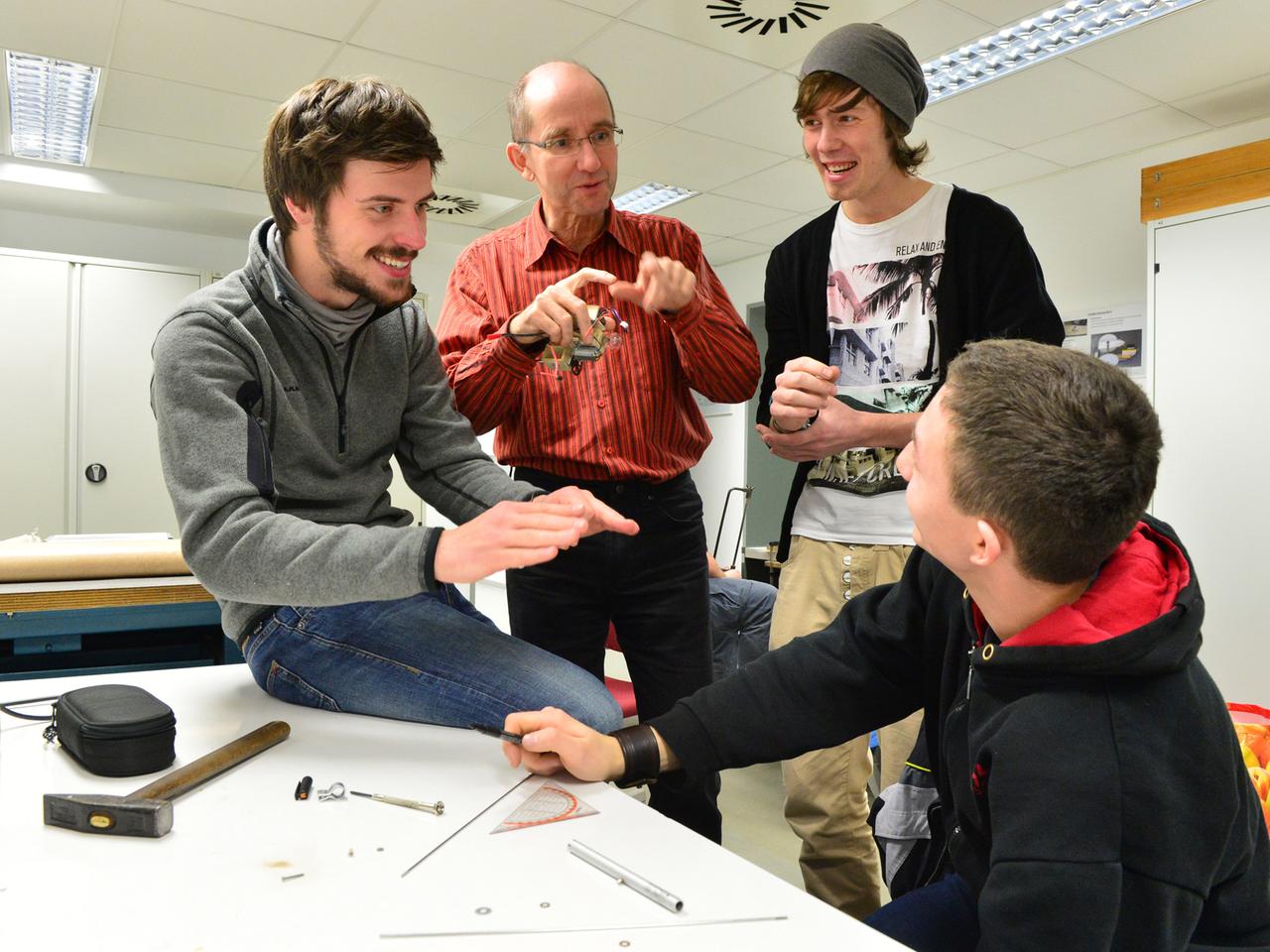 Die Studenten der Feinwerktechnik, Jacob Biermann (l), Martin Enderlein (2.v.r.), Dustin Erbes (r) und ihr Professor Martin Schröck (2.v.l.), sprechen am 13.12.2013 an der Fachhochschule in Jena (Thüringen) miteinander. Am 16. Dezember präsentieren die Erstsemester ihre Ergebnisse im diesjährigen Konstruktionswettbewerb. Die Studenten der Feinwerktechnik, Jacob Biermann (l), Martin Enderlein (2.v.r.), Dustin Erbes (r) und ihr Professor Martin Schröck (2.v.l.), sprechen am 13.12.2013 an der Fachhochschule in Jena (Thüringen) miteinander. Am 16. Dezember präsentieren die Erstsemester ihre Ergebnisse im diesjährigen Konstruktionswettbewerb.
