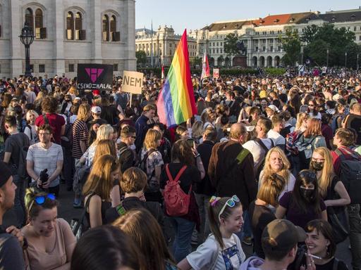 Viele Menschen protestieren in Budapest gegen ein Gesetz zu Homosexualität. In der Mitte ist eine Regenbogenfahne zu erkennen.