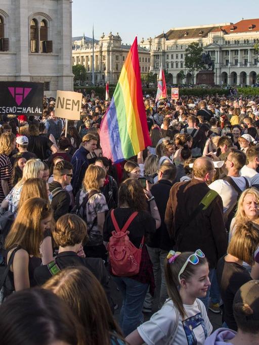 Viele Menschen protestieren in Budapest gegen ein Gesetz zu Homosexualität. In der Mitte ist eine Regenbogenfahne zu erkennen.