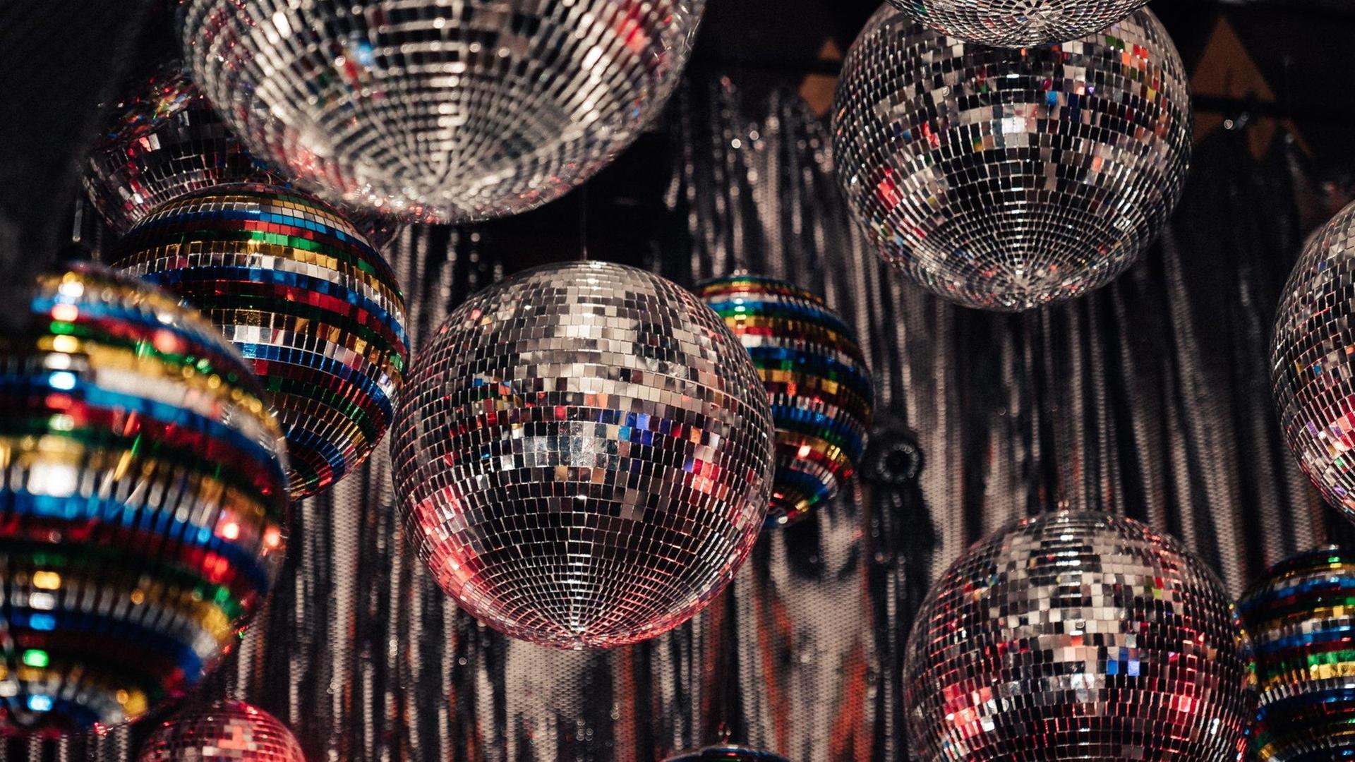 Viele glitzernden Discokugeln hängen von der Decke eines Clubs. Viele glitzernden Discokugeln hängen von der Decke eines Clubs.