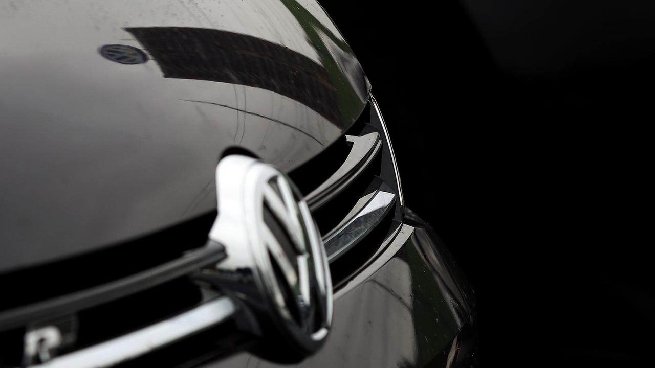 Logo von VW in Volkswagen reflektiert auf der Motorhaube eines VW-Autos Logo von VW in Volkswagen reflektiert auf der Motorhaube eines VW-Autos