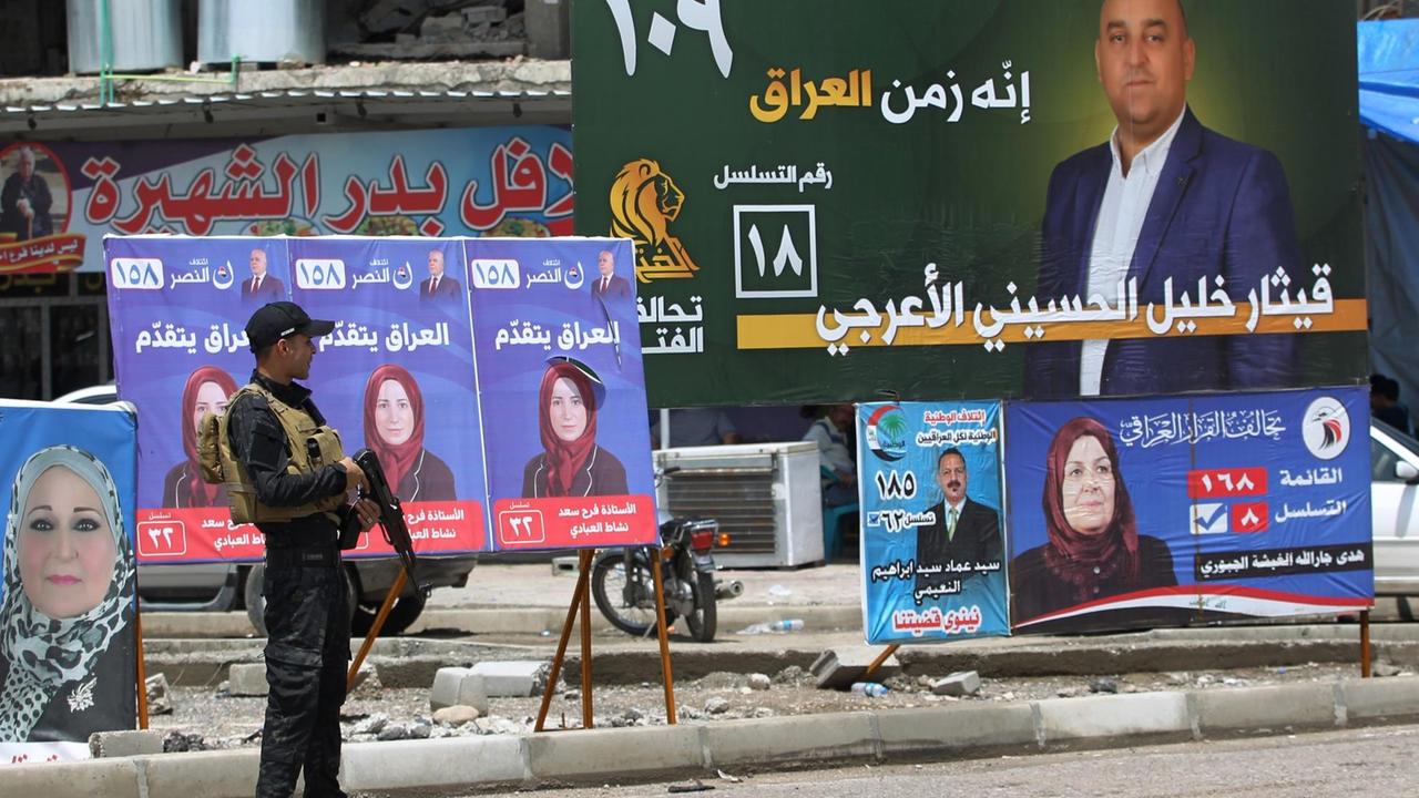 In Mossul steht ein irakischer Soldat vor Wahlplakaten. In Mossul steht ein irakischer Soldat vor Wahlplakaten.