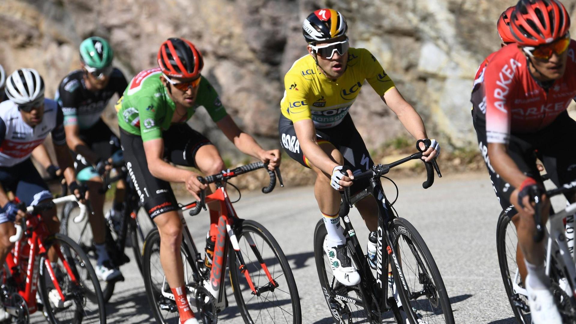 Mehrere Radprofis, unter ihnen der Deutsche Maximilian Schachmann im gelben Trikot, fahren am 14. März 2020 beim Radrennen Paris - Nizza. Mehrere Radprofis, unter ihnen der Deutsche Maximilian Schachmann im gelben Trikot, fahren am 14. März 2020 beim Radrennen Paris - Nizza.
