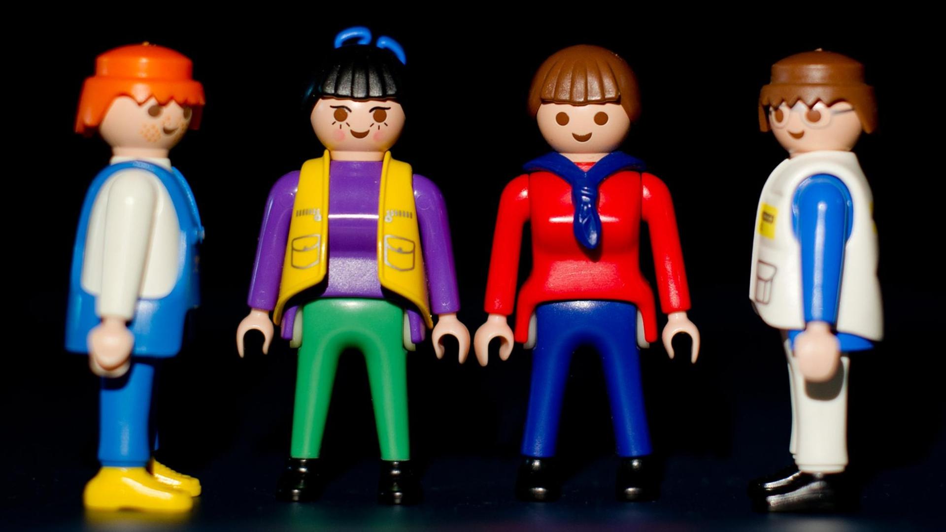 Zwei Playmobil-Frauen stehen zwischen zwei Playmobil-Männern Zwei Playmobil-Frauen stehen zwischen zwei Playmobil-Männern