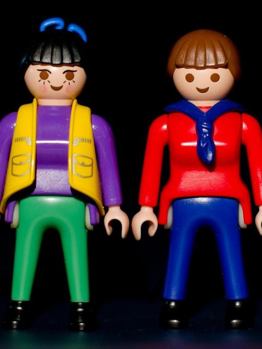 Zwei Playmobil-Frauen stehen zwischen zwei Playmobil-Männern