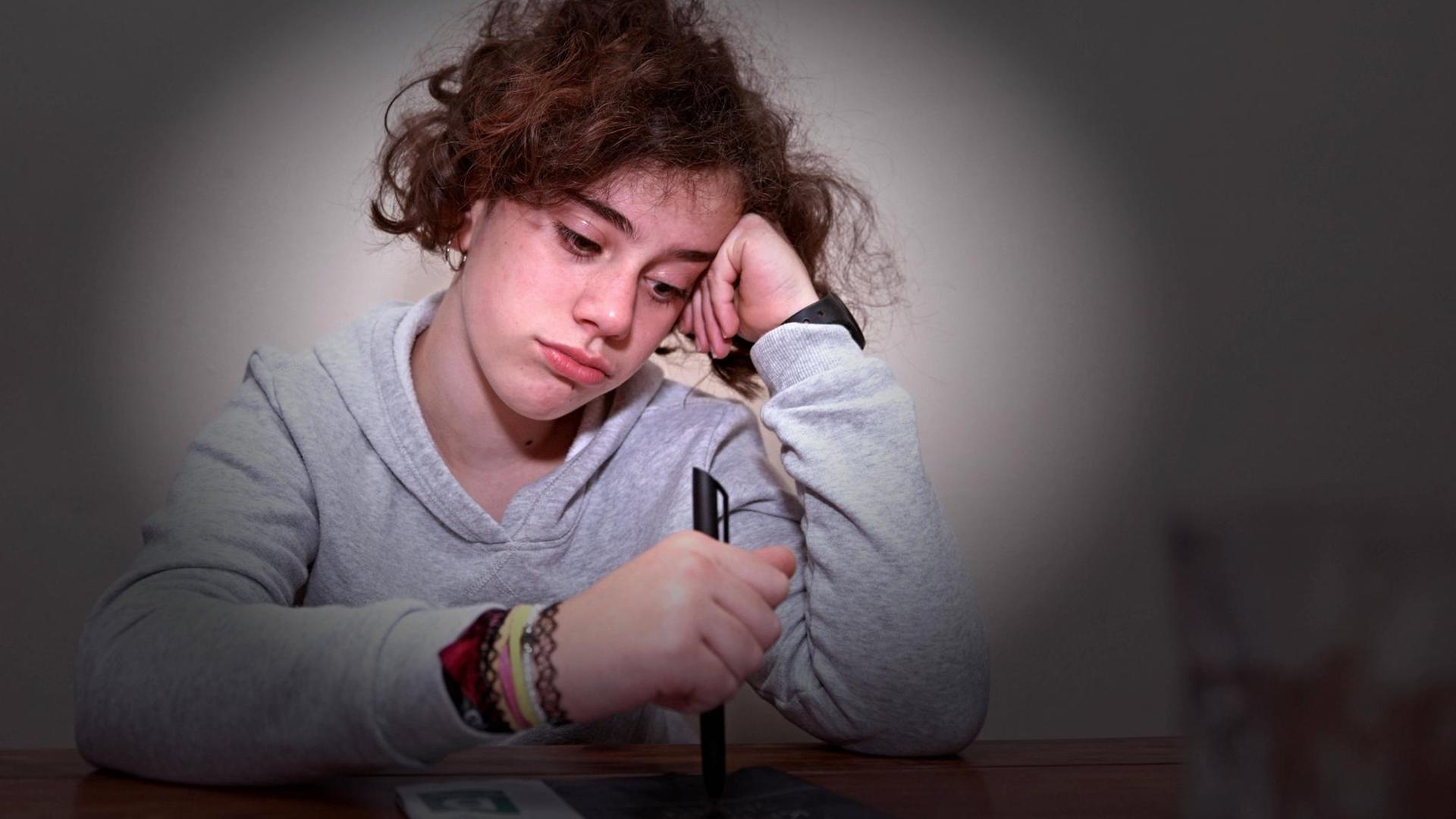 Unterricht von Zuhause in Corona-Zeiten: Ein Schulkind sitzt am Tisch, guckt traurig-gelangweilt und stützt den Kopf in die Hand (Symbolbild) Unterricht von Zuhause in Corona-Zeiten: Ein Schulkind sitzt am Tisch, guckt traurig-gelangweilt und stützt den Kopf in die Hand (Symbolbild)