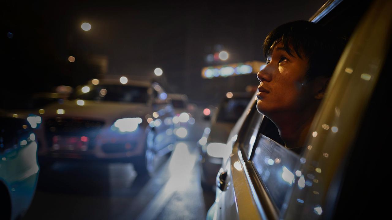Ein junger Chinese schaut aus einem Taxifenster, aufgenommen in Changsha/China.