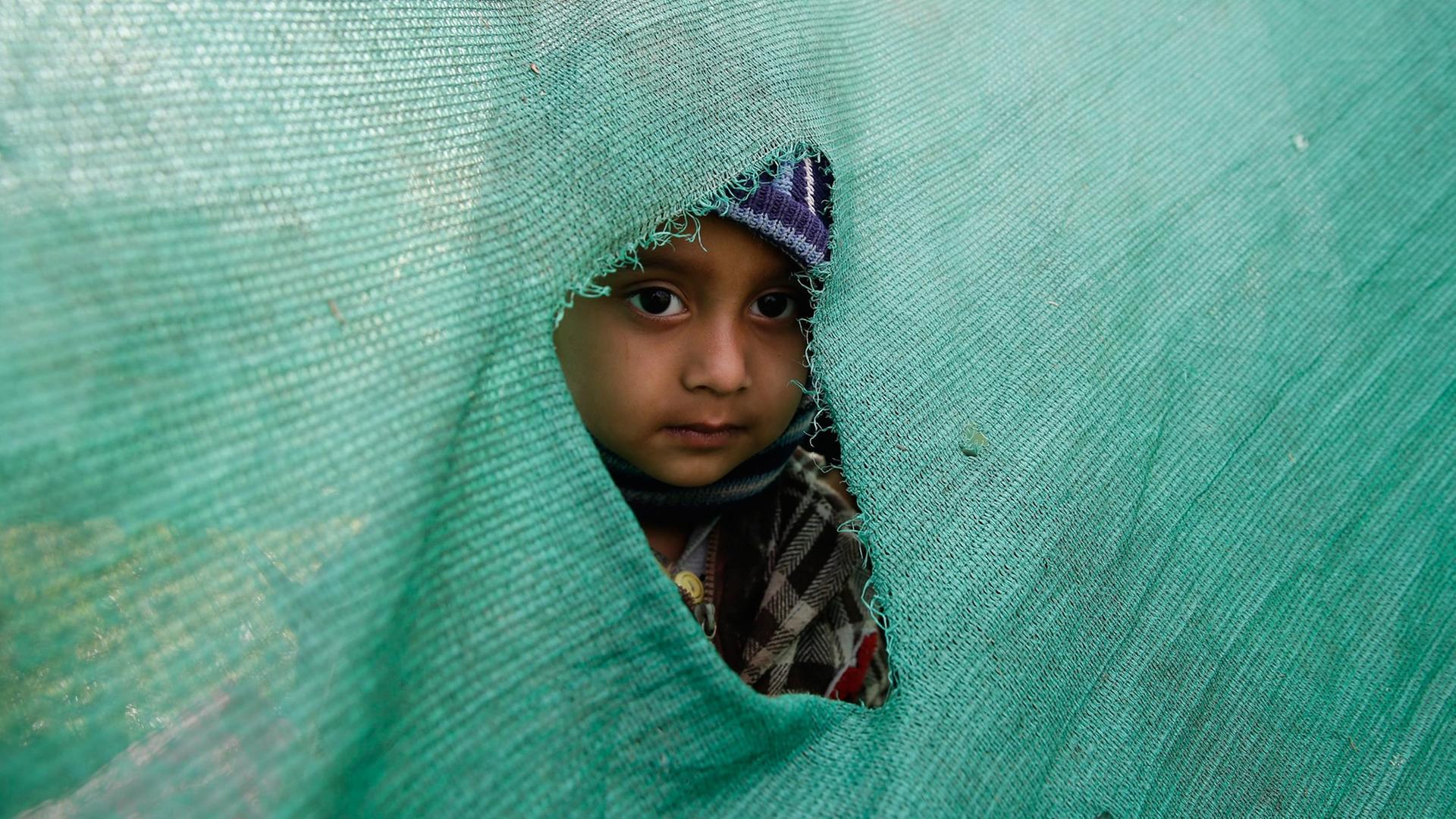 In Kathmandu schaut ein Kind durch ein Loch in einer Zeltwand nach draußen. A child peeks out of a hole in a temporary tent in an open ground in Kathmandu after a powerful earthquake followed by strong aftershocks struck Nepal, in Kathmandu, Nepal, 27 April 2015. In Kathmandu schaut ein Kind durch ein Loch in einer Zeltwand nach draußen. A child peeks out of a hole in a temporary tent in an open ground in Kathmandu after a powerful earthquake followed by strong aftershocks struck Nepal, in Kathmandu, Nepal, 27 April 2015.