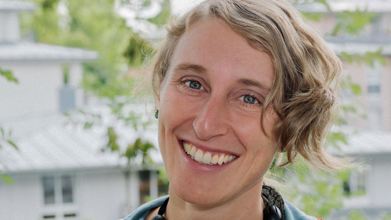 Porträtaufnahme von Katrin Pütz: ein Frau mit kurzen welligen blonden Haaren, die in die Kamera lacht. Porträtaufnahme von Katrin Pütz: ein Frau mit kurzen welligen blonden Haaren, die in die Kamera lacht.