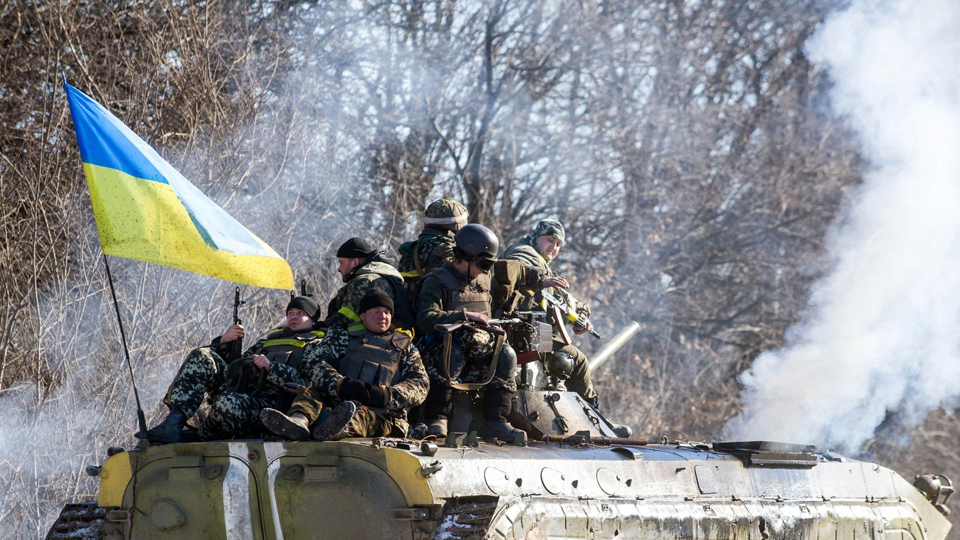 Ein Panzer mit ukrainischer Fahne und Soldaten zieht sich aus Debalzewe zurück. Ein Panzer mit ukrainischer Fahne und Soldaten zieht sich aus Debalzewe zurück.