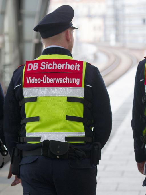 Sicherheitsmitarbeiter der Deutschen Bahn gehen in Berlin mit Spezialwesten und einer daran angebrachten Mini-Kamera über einen Bahnsteig im Bahnhof Alexanderplatz.