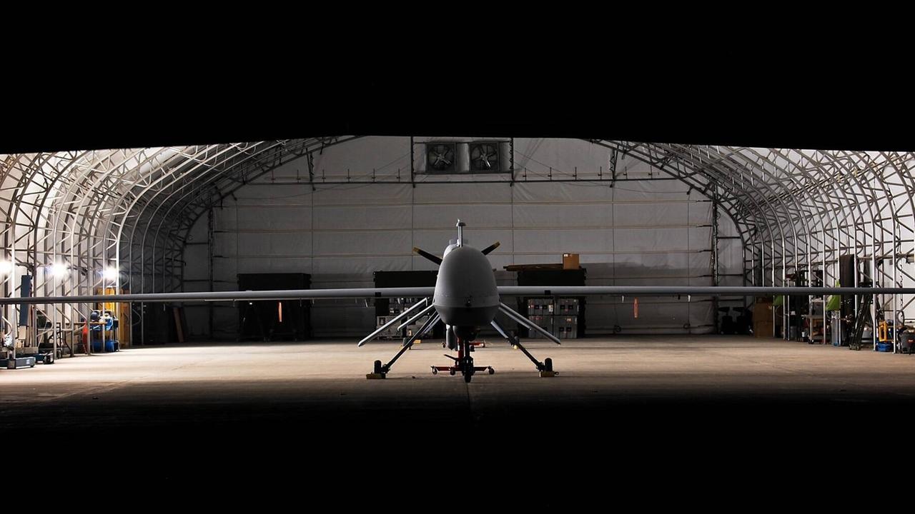 Predator-Drohne - ein unbemanntes Flugzeug, das 24 Stunden lang in der Luft bleiben und Überwachungs- und Raketenangriffe durchführen kann, während es von menschlichen Bedienern an einem entfernten Ort ferngesteuert wird. Predator-Drohne - ein unbemanntes Flugzeug, das 24 Stunden lang in der Luft bleiben und Überwachungs- und Raketenangriffe durchführen kann, während es von menschlichen Bedienern an einem entfernten Ort ferngesteuert wird.